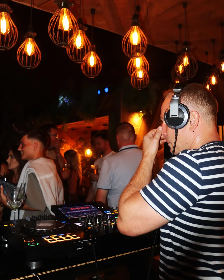 DJ playing under the pendant lights at a Soirée night